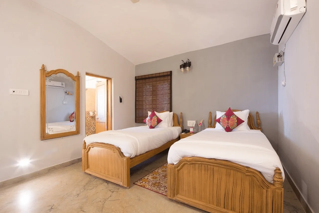 Twin bedroom with wooden beds at a premium jungle resort near Bandhavgarh